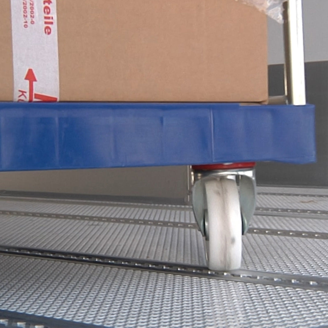 Rad eines Rollcontainers auf dem Boden eines Kühlfahrzeuges mit Lochschienen für Ladungssicherung