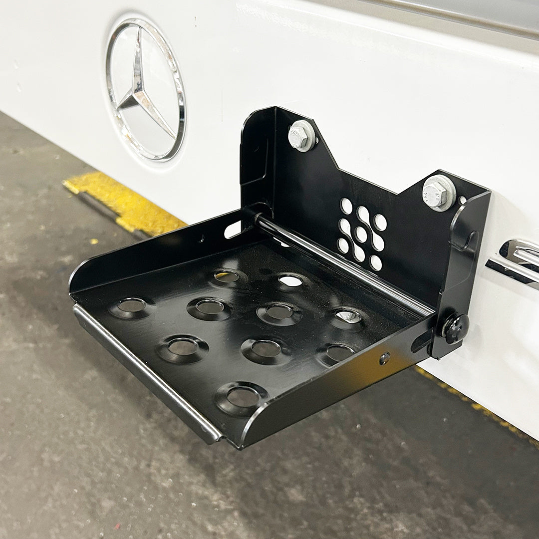 Ein schwarzer Klapptritt an einem Kültransporter