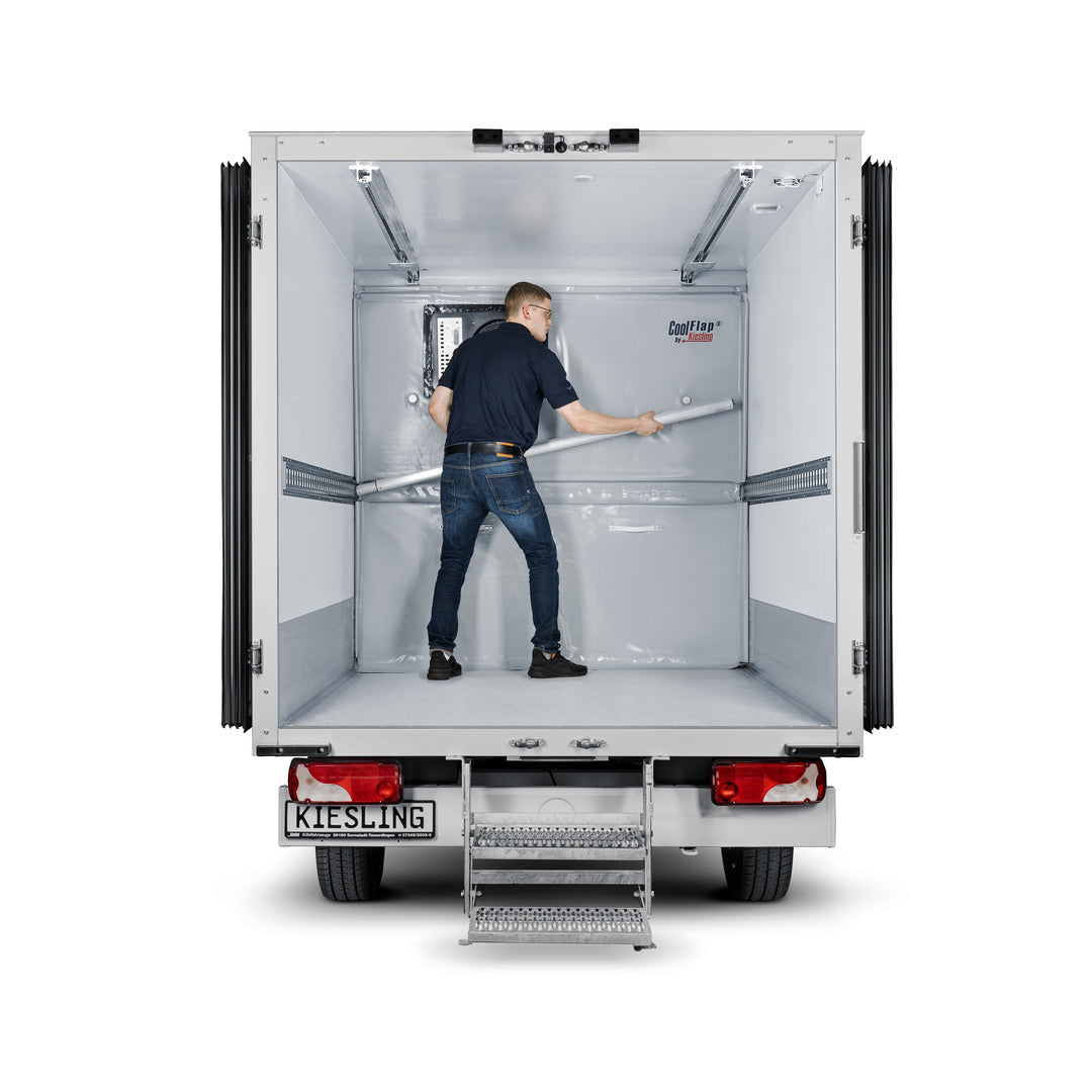 Innenraum eines Kühltransporters mit einer Trennwand Cool Flap, die von einem Mann  seitlich befestigt wird