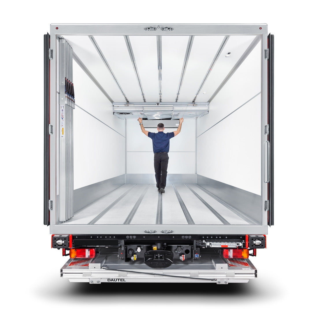 Im Kühl-Laderaum eines LKW wird eine Trennwand an der Decke verschoben.